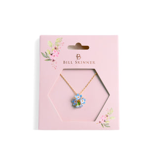 Necklace with a floral pendant in a 'Bill Skinner' branded pink box on a white background