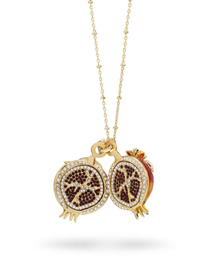 A gold pomegranate necklace showing the hand set red crystal seeds within 