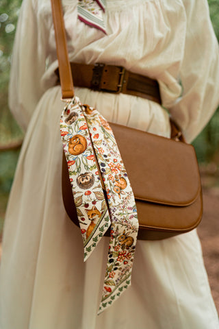 Forest Friends Scarf in ivory styled tied on handbag